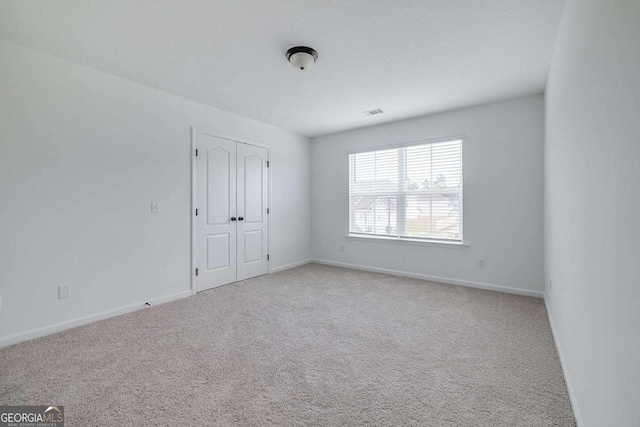 empty room featuring carpet flooring and baseboards