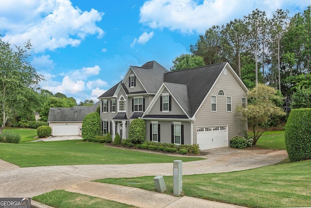 view of front of property featuring concrete driveway, a front yard, an attached garage, a standing seam roof, and stucco siding