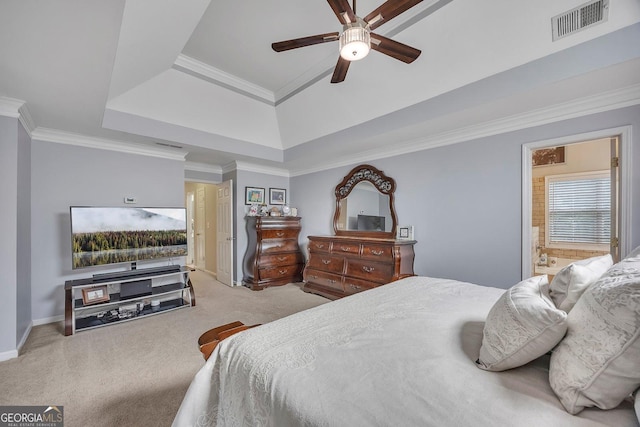 carpeted bedroom featuring baseboards, a raised ceiling, crown molding, ensuite bath, and ceiling fan