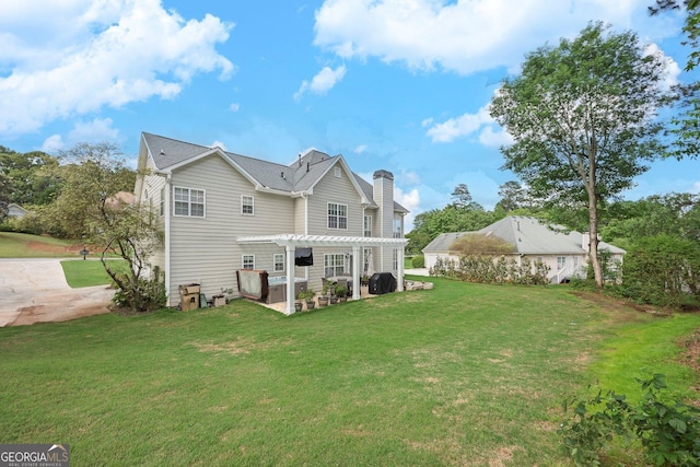 rear view of property with a pergola, a lawn, a patio area, and a chimney