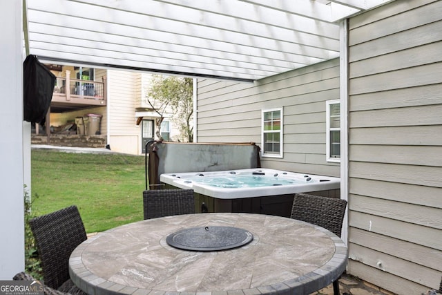 view of patio with a hot tub and outdoor dining space