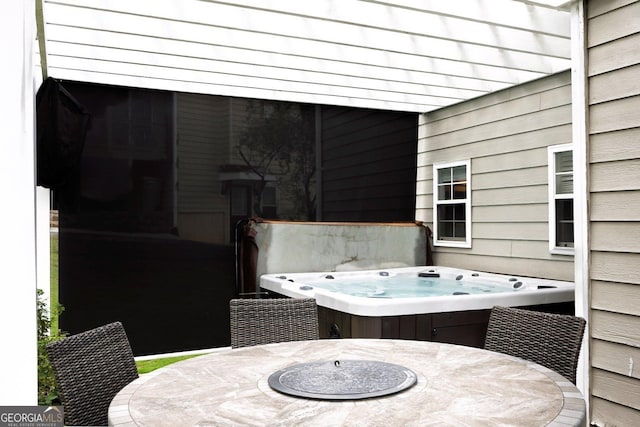 view of patio / terrace featuring outdoor dining area and a hot tub