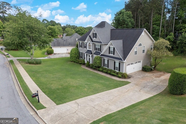 view of front of house with an attached garage, driveway, a standing seam roof, a front lawn, and roof with shingles