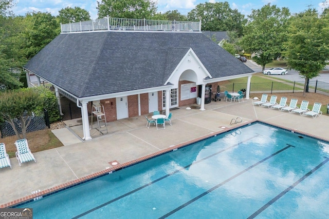 community pool featuring french doors, fence, and a patio area