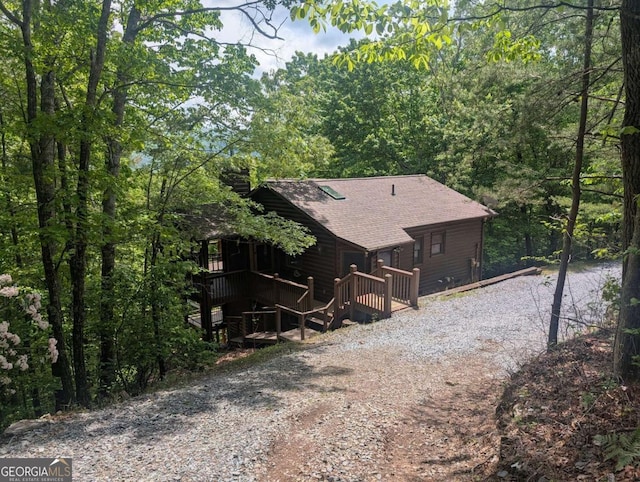 350 Left Turn Unit 15, Blue Ridge, GA 30513 - view of side of property with dirt driveway, roof with shingles, a wooden deck, and a view of trees