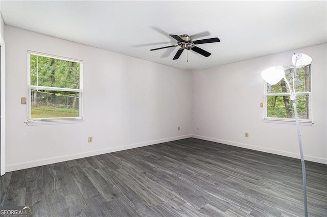 unfurnished room with plenty of natural light, dark wood-style flooring, and baseboards