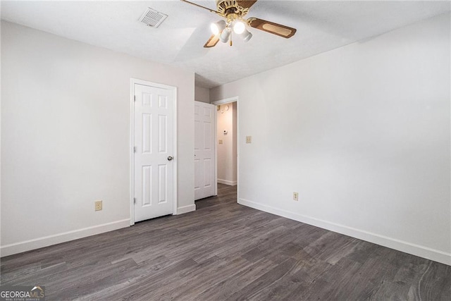 unfurnished bedroom featuring dark wood-style flooring, baseboards, and a ceiling fan