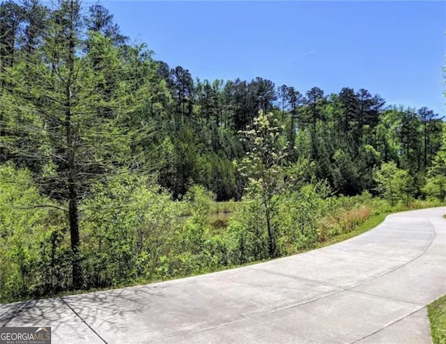 view of road featuring a forest view