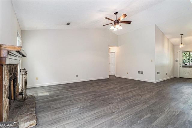 unfurnished living room featuring a fireplace with raised hearth, a ceiling fan, dark wood-type flooring, baseboards, and lofted ceiling
