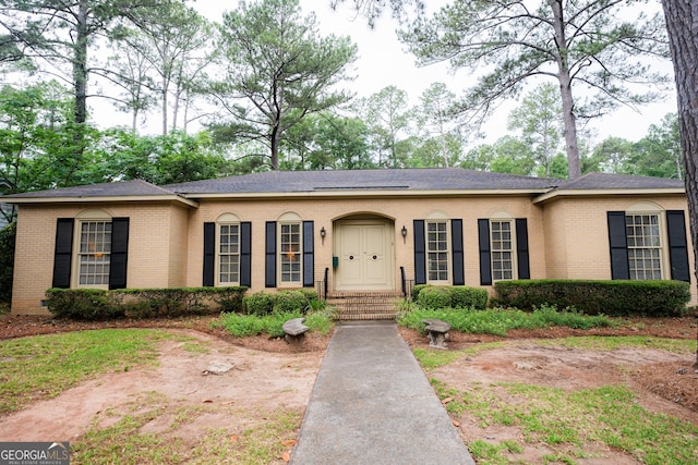 single story home with brick siding and a shingled roof