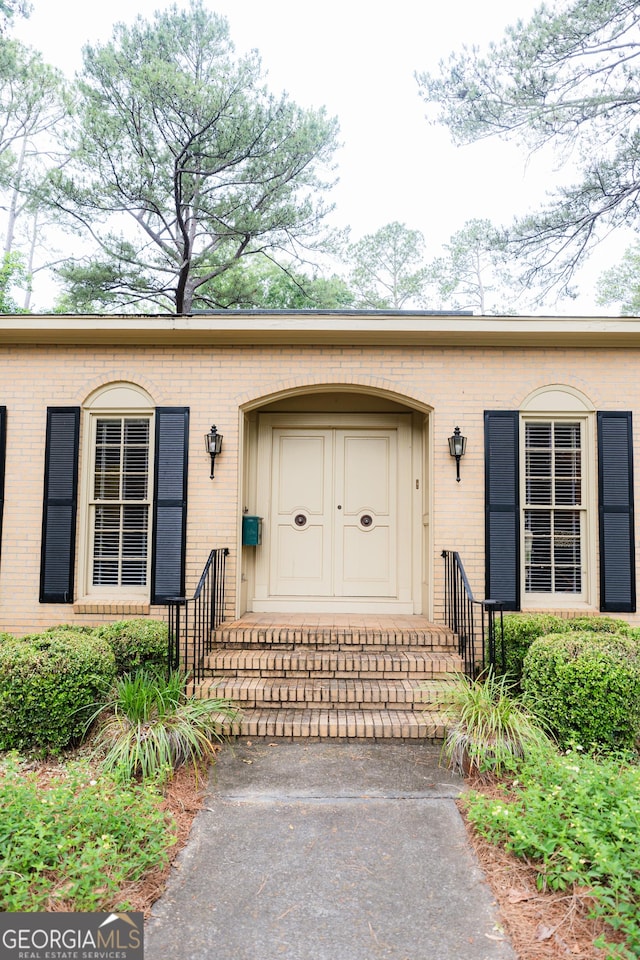 doorway to property with brick siding