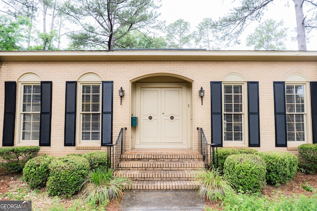 entrance to property featuring brick siding