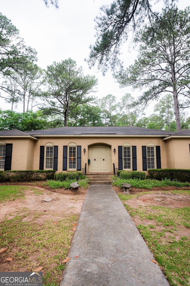 ranch-style house featuring brick siding