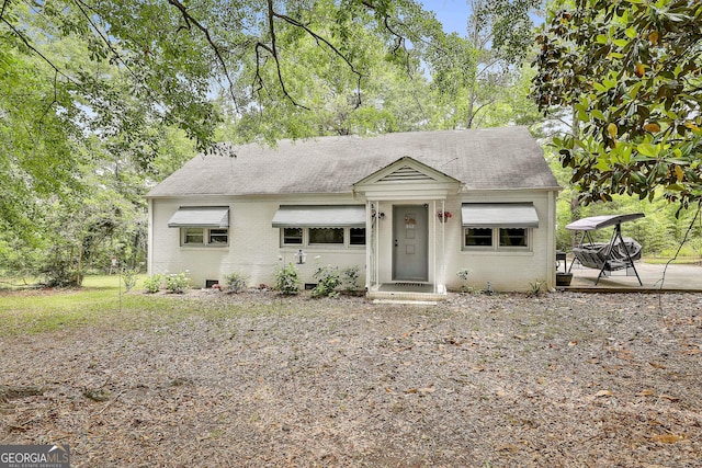 view of front of home featuring brick siding, roof with shingles, and a patio
