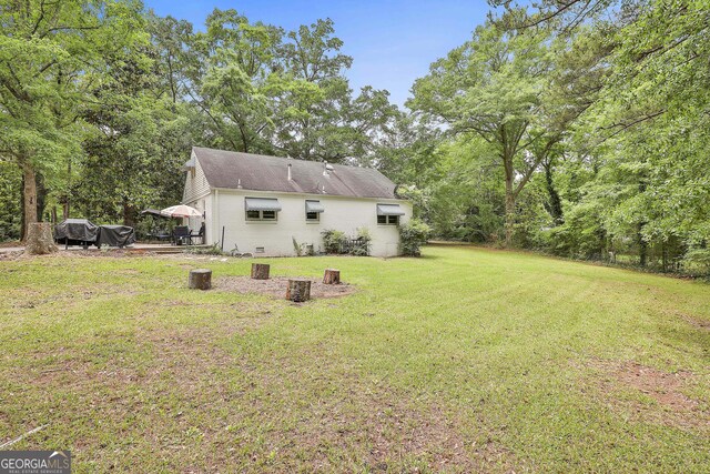 back of house featuring a yard and brick siding