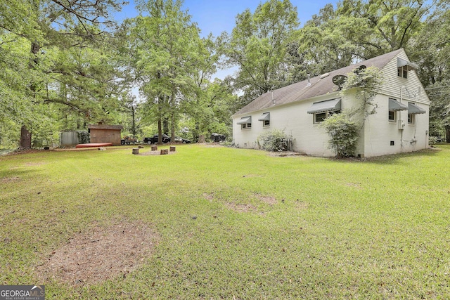 view of grassy yard with view of wooded area