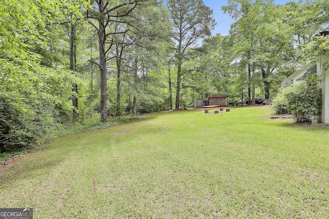 view of green lawn featuring an outbuilding and a shed