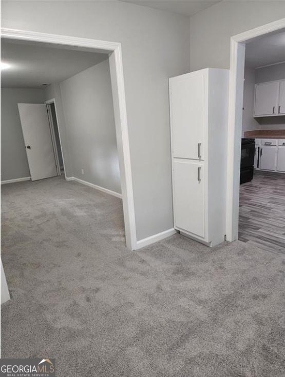 carpeted spare room featuring baseboards