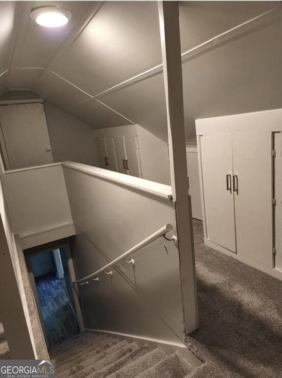 staircase with carpet flooring and vaulted ceiling