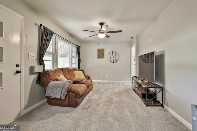 living area with ceiling fan, carpet flooring, and baseboards