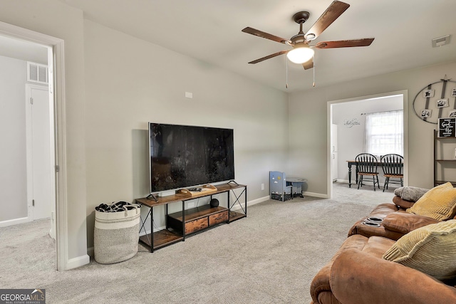 living room with carpet flooring, a ceiling fan, and baseboards