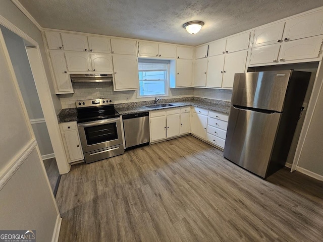 2860 Cocklebur Cove Ct, Decatur, GA 30034 - kitchen featuring appliances with stainless steel finishes, dark countertops, a textured ceiling, under cabinet range hood, and white cabinetry