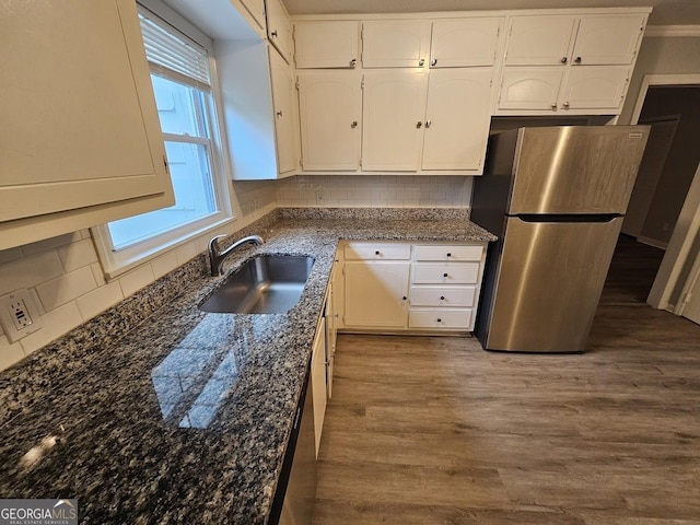 2860 Cocklebur Cove Ct, Decatur, GA 30034 - kitchen featuring freestanding refrigerator, a sink, white cabinets, decorative backsplash, and wood finished floors