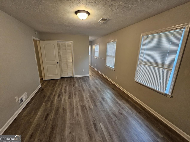 2860 Cocklebur Cove Ct, Decatur, GA 30034 - unfurnished bedroom featuring dark wood finished floors, baseboards, a closet, and a textured ceiling