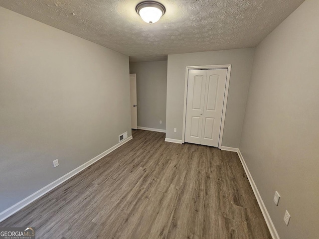 2860 Cocklebur Cove Ct, Decatur, GA 30034 - unfurnished bedroom featuring wood finished floors, a textured ceiling, a closet, and baseboards