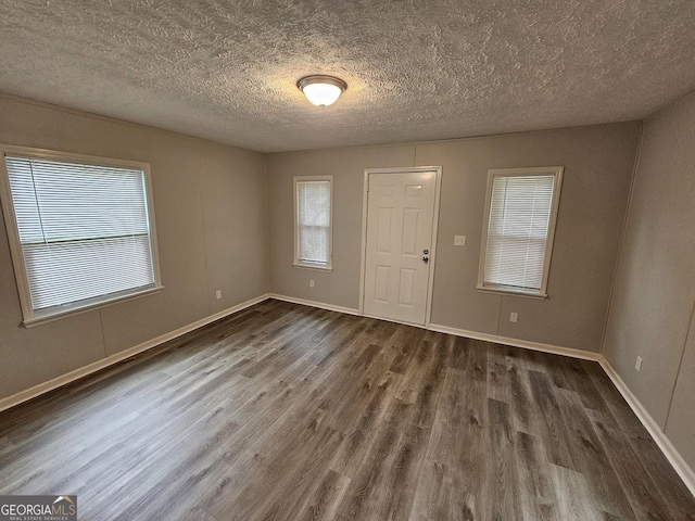 2860 Cocklebur Cove Ct, Decatur, GA 30034 - empty room featuring dark wood-style flooring, healthy amount of natural light, baseboards, and a textured ceiling