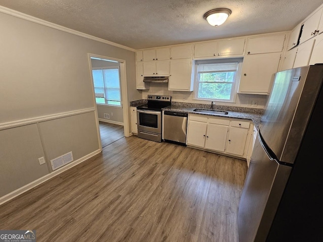 2860 Cocklebur Cove Ct, Decatur, GA 30034 - kitchen with stainless steel appliances, a sink, under cabinet range hood, dark countertops, and decorative backsplash