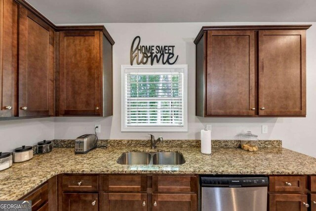 139 Coldwater Ln, Griffin, GA 30224 - kitchen with stainless steel dishwasher, light stone counters, and dark brown cabinetry