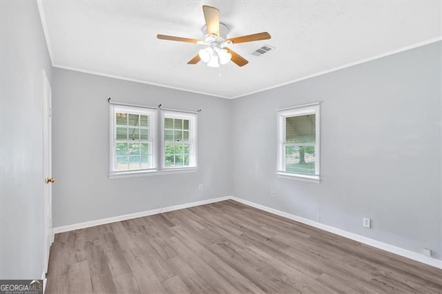 empty room featuring wood finished floors, ceiling fan, crown molding, and baseboards