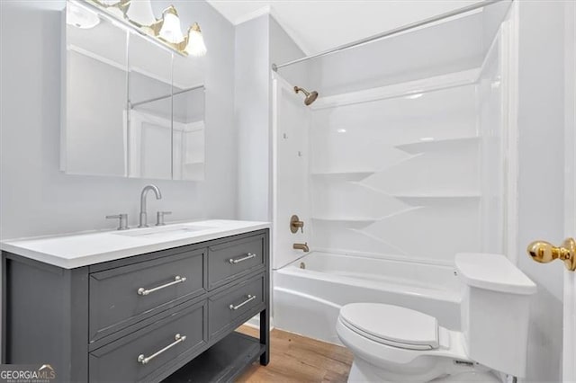 full bathroom with toilet, wood finished floors, shower / bathtub combination, and vanity
