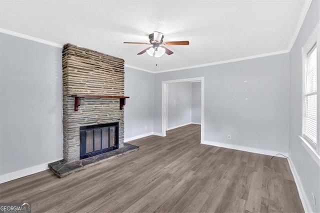 unfurnished living room with ceiling fan, a large fireplace, wood finished floors, baseboards, and ornamental molding