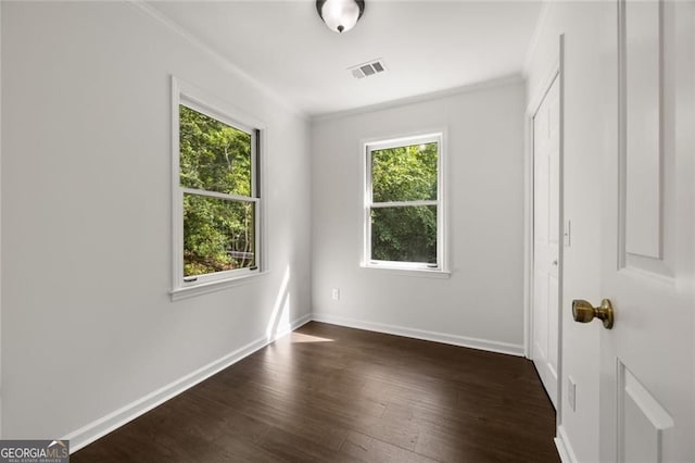1260 Heards Ferry Rd, Sandy Springs, GA 30328 - unfurnished bedroom with multiple windows, crown molding, baseboards, dark wood-style flooring, and a closet