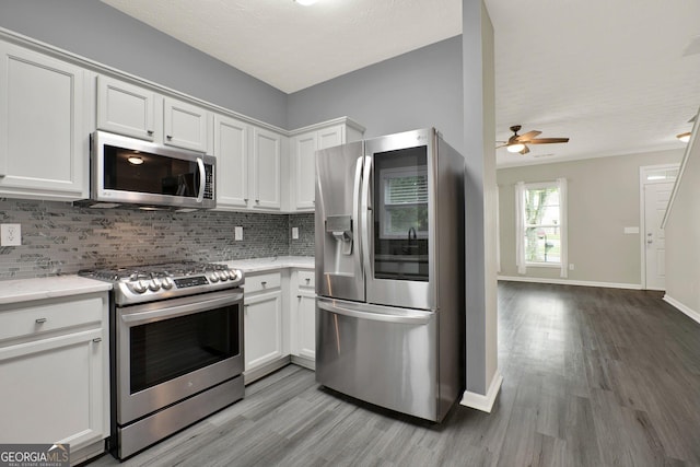 556 Poplar Bnd, Canton, GA 30114 - kitchen with stainless steel appliances, light wood-style flooring, decorative backsplash, and white cabinetry