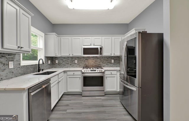 556 Poplar Bnd, Canton, GA 30114 - kitchen with appliances with stainless steel finishes, a sink, white cabinetry, and backsplash