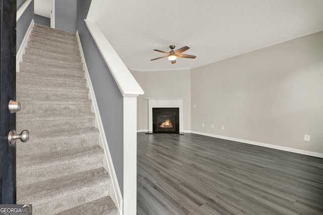556 Poplar Bnd, Canton, GA 30114 - unfurnished living room featuring a ceiling fan, stairs, dark wood finished floors, a fireplace with flush hearth, and baseboards