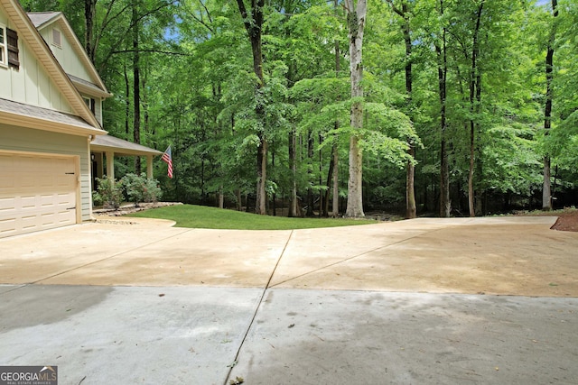 121 Hidden Springs Dr, Lagrange, GA 30240 - view of patio featuring concrete driveway, a garage, and a view of trees