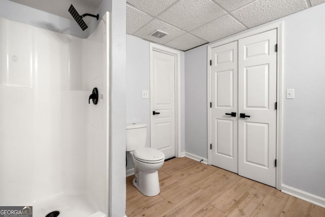 3078 Milford Chase SW, Marietta, GA 30008 - bathroom with a shower stall, wood finished floors, toilet, baseboards, and a paneled ceiling