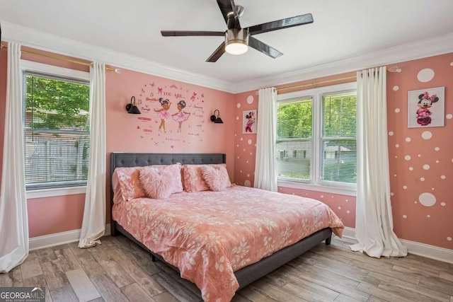 bedroom featuring ornamental molding, wood finished floors, baseboards, and ceiling fan