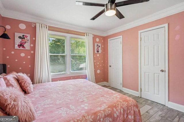 bedroom featuring light wood finished floors, crown molding, baseboards, and a ceiling fan
