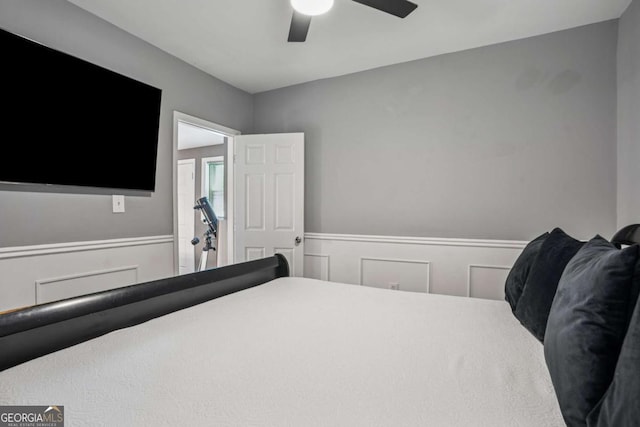bedroom featuring wainscoting and a ceiling fan