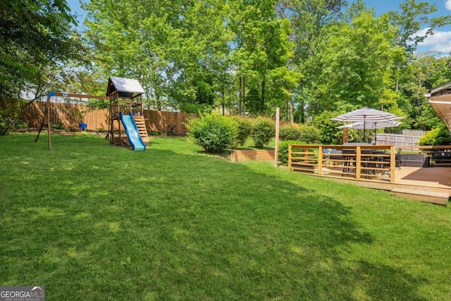 view of yard with a playground and a wooden deck