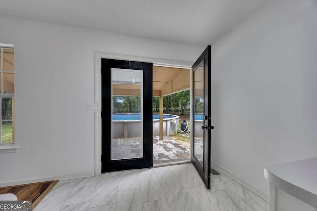 entryway featuring french doors, baseboards, and light marble finish flooring