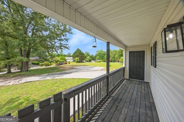 wooden terrace with a porch and a lawn