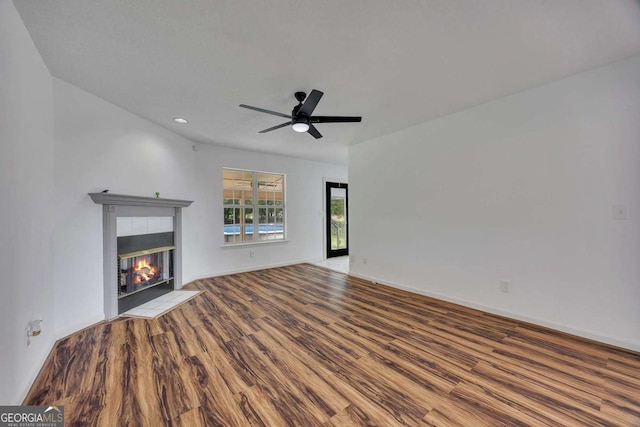 unfurnished living room featuring wood finished floors, a fireplace, ceiling fan, baseboards, and recessed lighting