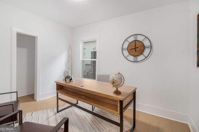 home office with baseboards and light wood-style floors