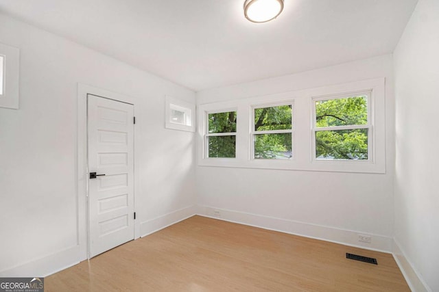 spare room with light wood-type flooring and baseboards